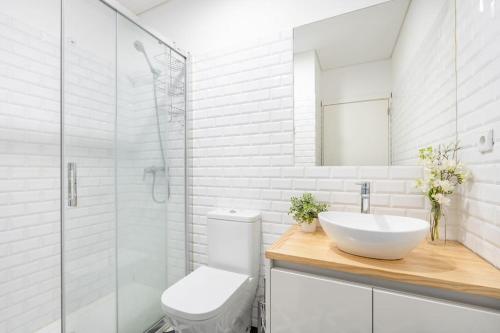 La salle de bains est pourvue d'un lavabo, de toilettes et d'une douche. dans l'établissement Bonfim Cozy Home Studio, à Porto