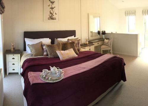 a bedroom with a large bed with a tray on it at Henfields Country Retreat in Otterhampton