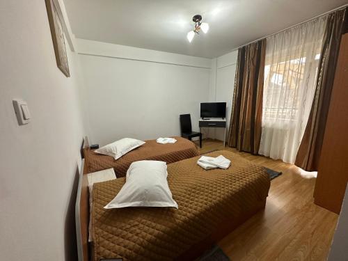 Habitación de hotel con 2 camas y escritorio en Casa Rustic cazare, en Piteşti