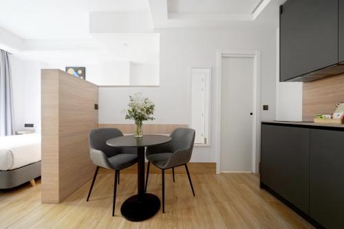 numa I Goya Apartments في مدريد: مطبخ وغرفة طعام مع طاولة وكرسيين