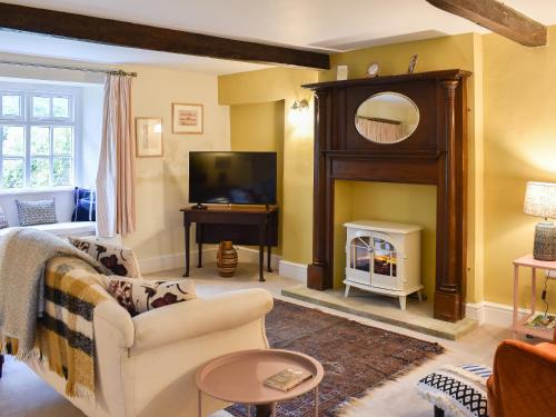 a living room with a fireplace and a television at 2 Sulphur Wells at Broughton Sanctuary in Broughton