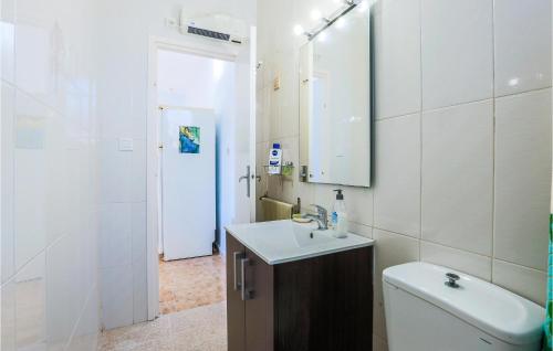 uma casa de banho com um WC, um lavatório e um espelho. em 2 Bedroom Beautiful Home In Cartagena em Cartagena