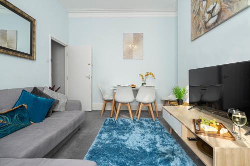 ein Wohnzimmer mit einem Sofa und einem Tisch in der Unterkunft St James Place 4 bed Apt with JOIVY in Plymouth