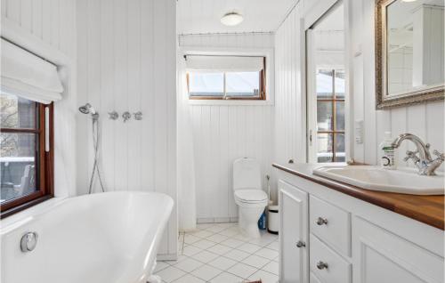 a bathroom with a tub and a toilet and a sink at Holiday Home Tornehagen Holbæk Ii in Holbæk