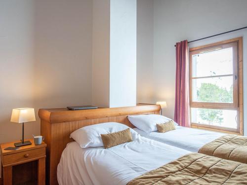 a bedroom with two beds and a window at Résidence Pierre & Vacances Premium Arc 1950 Le Village in Arc 1950