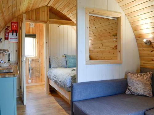 a small room with a bed and a couch at Lowside Farm Glamping in Troutbeck