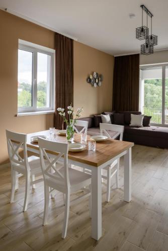 a dining room with a white table and chairs at Таун Тераса 2 поверхи by Willox in Chernivtsi