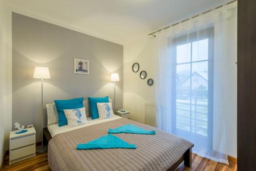 a bedroom with a bed with blue towels on it at Apartamenty NCNK Willa Turkusowa in Kąty Rybackie