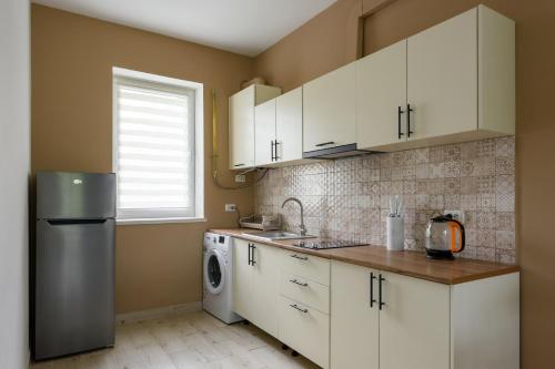 a kitchen with white cabinets and a washer and dryer at Таун Тераса 2 поверхи by Willox in Chernivtsi