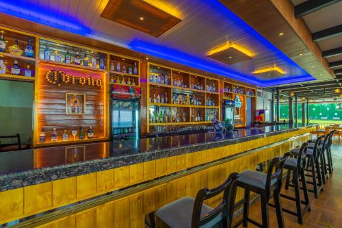 a bar at a restaurant with a row of chairs at La Cabana Beach & Spa, By Ashvem Beach in Mandrem