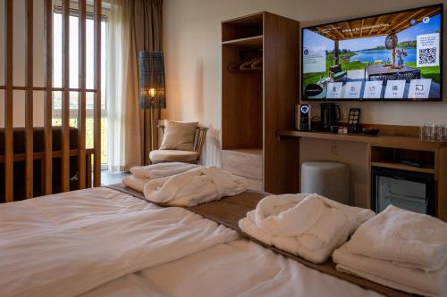 a hotel room with a bed with towels on it at Parc Maasresidence Thorn Lake View Hotel Rooms in Thorn