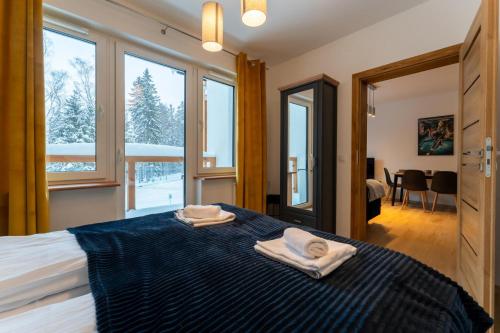 une chambre avec un lit avec deux serviettes dessus dans l'établissement Apartament Reglowy Raj - z prywatnym parkingiem by SpaceApart, à Szklarska Poręba