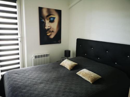 - une chambre avec un lit noir et 2 oreillers dans l'établissement Appart 431, port Soleil au village naturiste, au Cap d'Agde