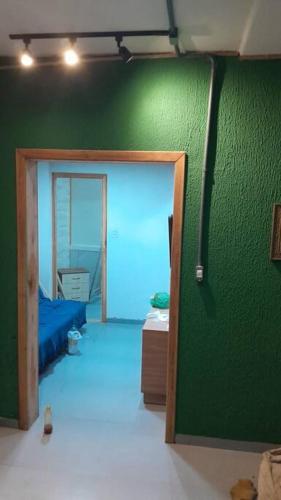 Cette chambre est dotée d'un mur vert et d'une porte. dans l'établissement Lindo apartamento, Mar grosso, à Laguna