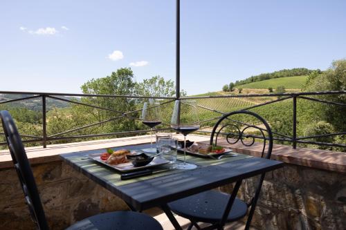 a table with food and wine glasses on a balcony at Fattoria Poggerino in Radda in Chianti