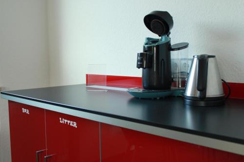 - un comptoir noir avec une cafetière dans l'établissement Restaurant Ollex and beds Zimmer 2, à Bliesdorf
