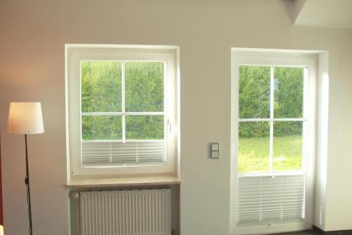 2 fenêtres dans une pièce avec radiateur dans l'établissement Restaurant Ollex and beds Zimmer 2, à Bliesdorf