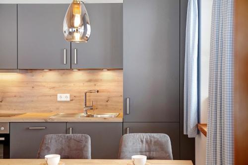 a kitchen with gray cabinets and a table with chairs at Ferienwohnung Gletschernelke in Grainau