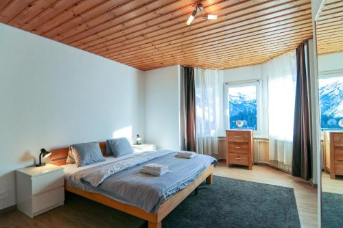 ein Schlafzimmer mit einem großen Bett und einer Holzdecke in der Unterkunft Miraflor Carmen - Arosa Holiday in Arosa