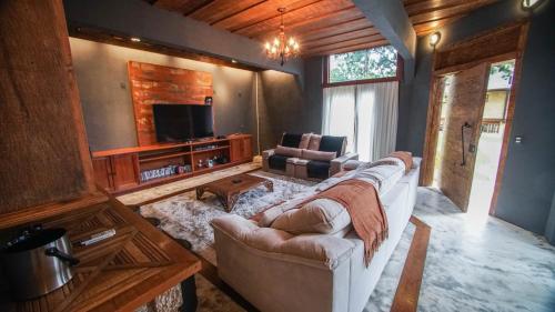 a living room with a couch and a tv at Pousada Terra Crua in Visconde De Maua