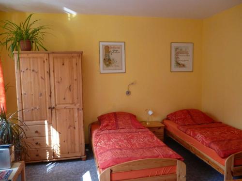 a bedroom with two twin beds and a cabinet at Ferienwohnungen Am Breitstrom in Erfurt