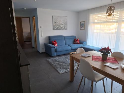 sala de estar con sofá azul y mesa en FeelHome Bruneck, en Brunico