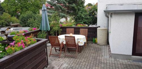 a patio with a table and chairs and an umbrella at Ferienwohnung Käuzchen in Erfurt