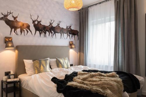 a bedroom with a bed with deer heads on the wall at VacationClub - Spokojna 24E Apartament B1 in Wisła