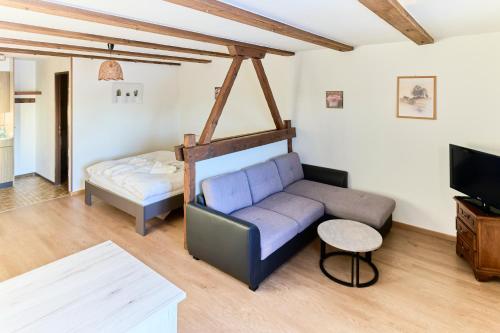 a living room with a couch and a bed at Auberge du Peu-Péquignot in Le Noirmont