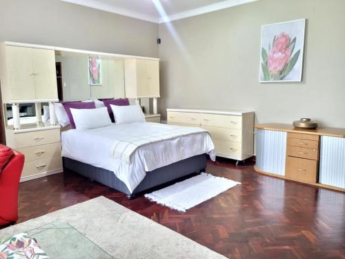 ein Schlafzimmer mit einem großen Bett mit weißen und violetten Kissen in der Unterkunft City Gate Two in Pietermaritzburg