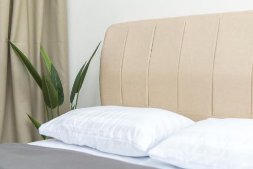 a bed with a white pillow and a headboard at FxA Studios Core Soho Suites KLIA 1 & 2 Sepang FREE WIFI in Sepang
