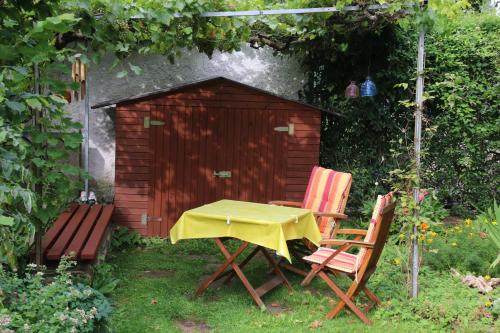 einen Tisch und zwei Stühle vor einer Hundehütte in der Unterkunft Ferienwohnung Blosenburgblick in Erfurt