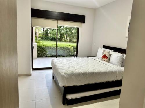 a bedroom with a bed and a large window at Private Modern Condo by Jac Beach in Jacó