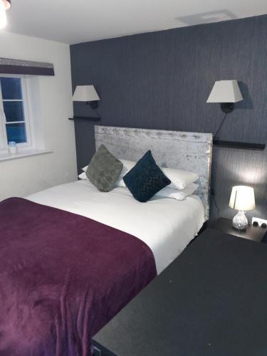 a bedroom with a large white bed with two pillows at Silverstone White House in Silverstone