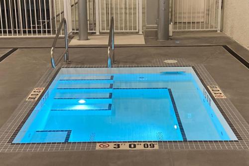 a large blue swimming pool in a building at Snow Ghost Inn 326 in Big White
