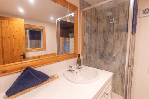 a bathroom with a sink and a shower at Tigh Lachie at Mary's Thatched Cottages, Elgol, Isle of Skye in Elgol