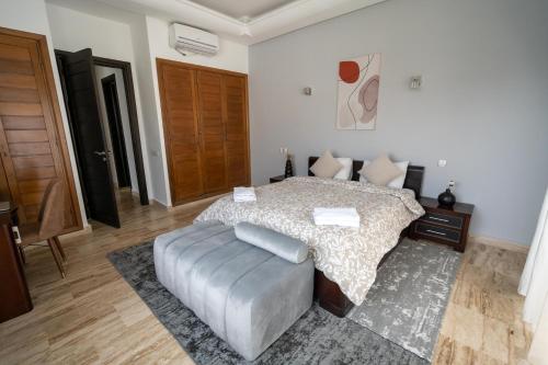 um quarto com uma cama e um repousa-pés em Moderne appart résidence privée em Tânger