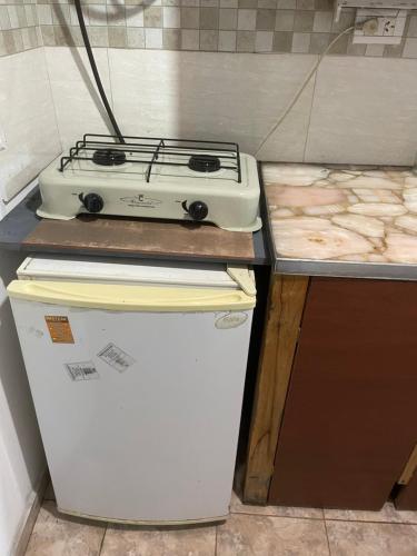 um fogão em cima de um frigorífico numa cozinha em Departamentos mora em Santa Teresita