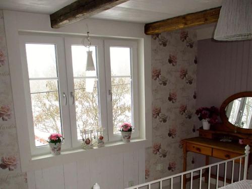 two windows in a bedroom with flowers on the wall at Flybo Sjöaborg, Smaland, South Sweden in Åseda