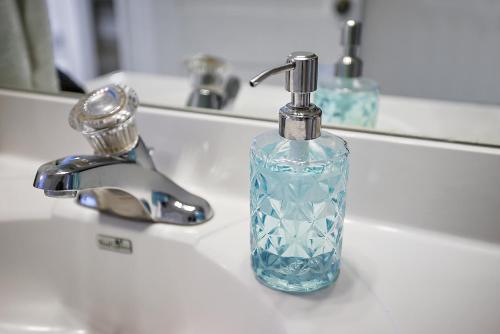 eine blaue Seifenflasche auf einem Waschbecken in der Unterkunft Downtown Digs~King Bed~UPSTAIRS Apartment~Downtown Eustis in Eustis