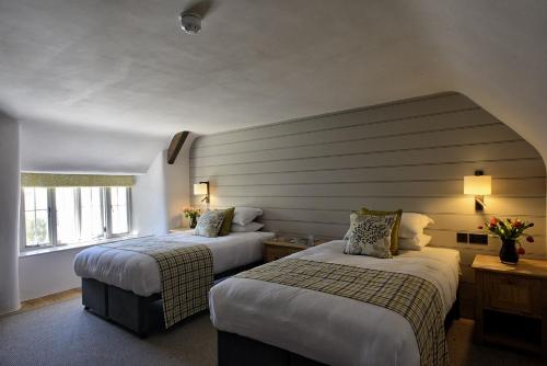 a hotel room with two beds and a window at Ring of Bells in North Bovey