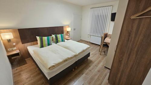 a bedroom with a large bed with a wooden headboard at Gästehaus Grunewald Bed & Breakfast in Heiden