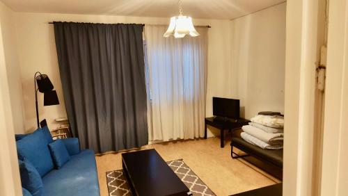 2 room Apartment in Hammarby by Stockholm City في ستوكهولم: غرفة معيشة مع أريكة زرقاء ونافذة