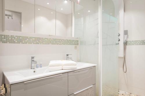 a white bathroom with a sink and a shower at Famille, Parking, Balnéo - 15min Centre in Strasbourg