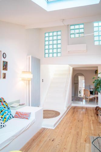 - un salon avec un canapé blanc et des escaliers dans l'établissement Duplex au cœur du vieux Nice, à Nice