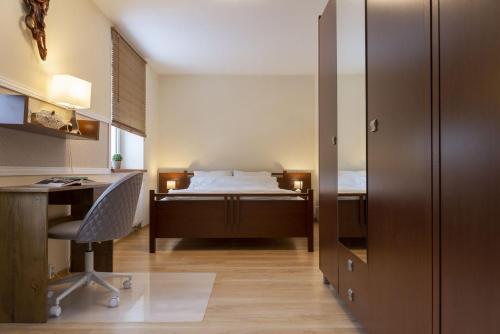 a bedroom with a bed and a desk and a desk at VacationClub - Bukowa 6B Apartament 26 in Wisła