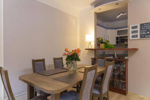 comedor con mesa de madera y sillas en VacationClub - Bukowa 6B Apartament 26, en Wisła