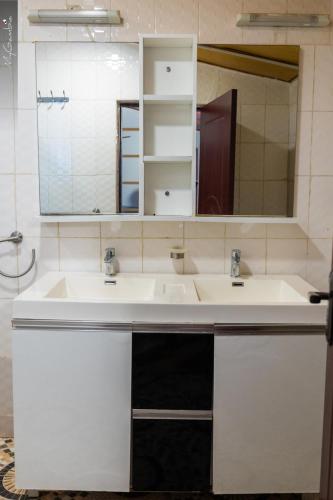 a bathroom with two sinks and a mirror at Sweet Mama in Bijilo