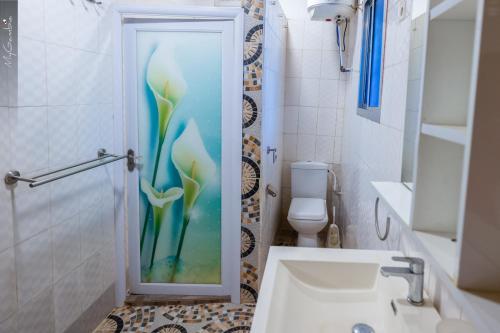 a bathroom with a shower with a glass door at Sweet Mama in Bijilo