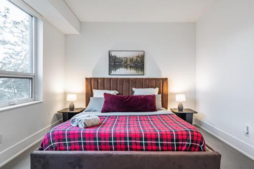 a bedroom with a bed with a plaid blanket at Luxury Properties in Toronto Downtown Core in Toronto